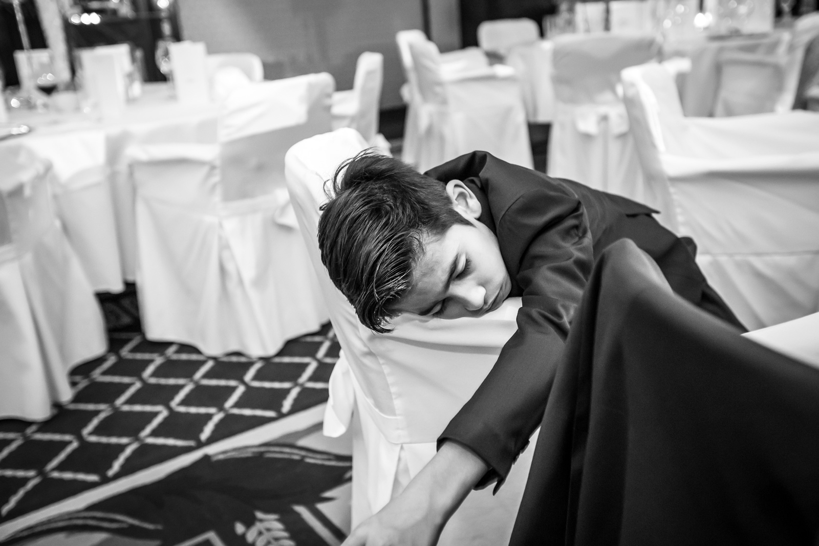 Schlafender Junge bei Hochzeitsfeier 